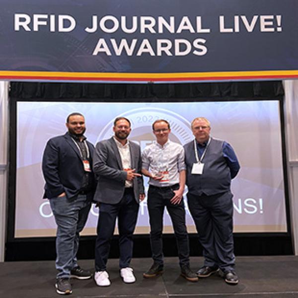 RFiD Discovery team with customer receiving RFID Journal award on stage