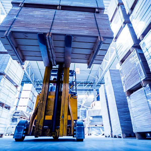 Forklift lifting pallet in warehouse